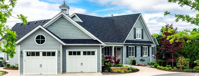 White carriage-house style garage doors on a blue-gray home