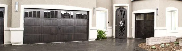 Wayne Dalton dark-stained wood garage doors on a stucco home