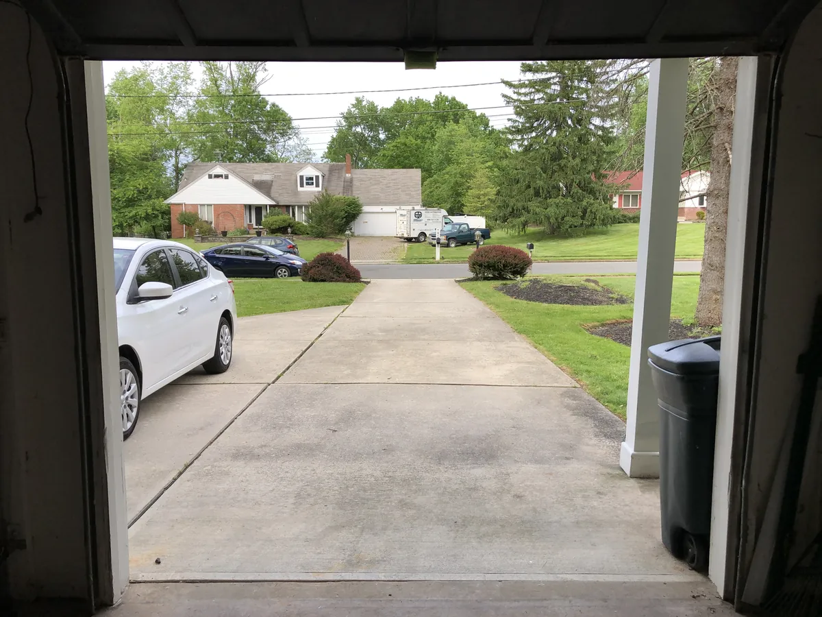 View from inside a garage looking out at the driveway