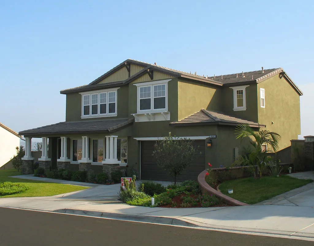 Two-story stucco home with a dark garage door